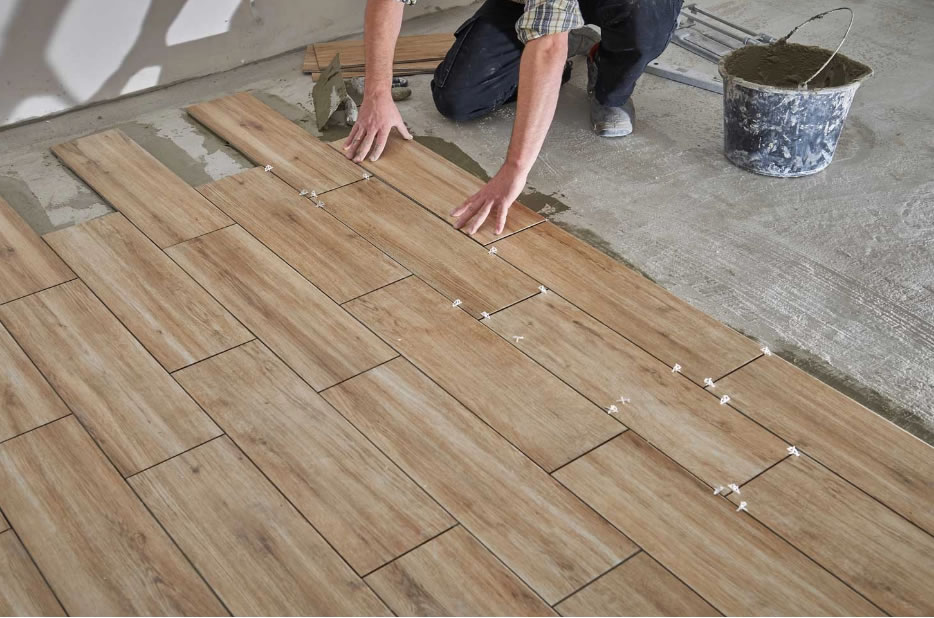 man installing tile flooring
